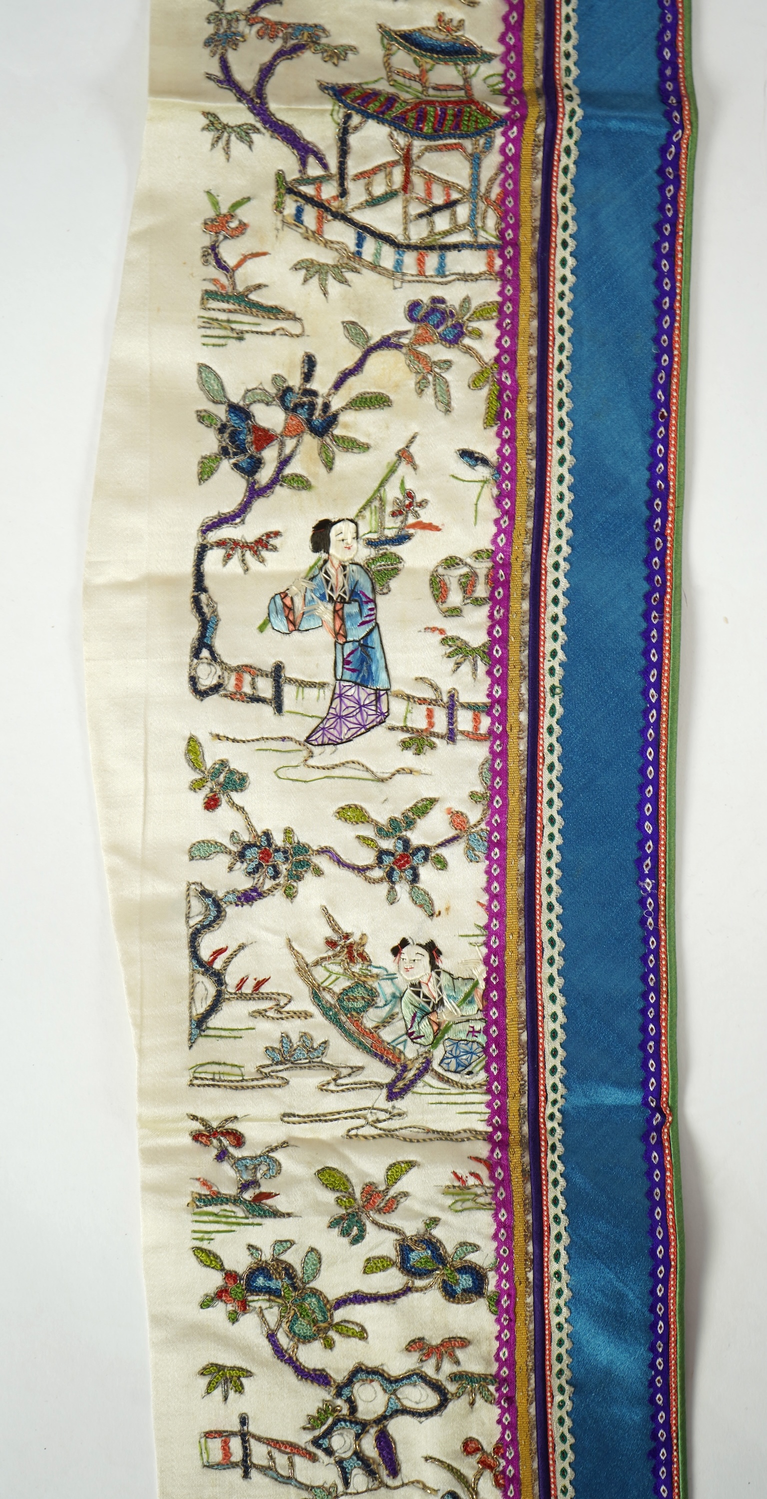 A Chinese embroidered silk panel of uncut robe borders, eleven similar sleeve panels and two other items, late Qing dynasty